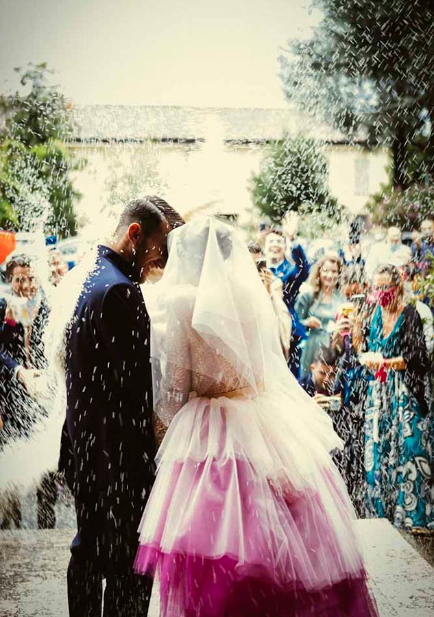 gli sposi all'uscita dalla chiesa sotto la pioggia di riso