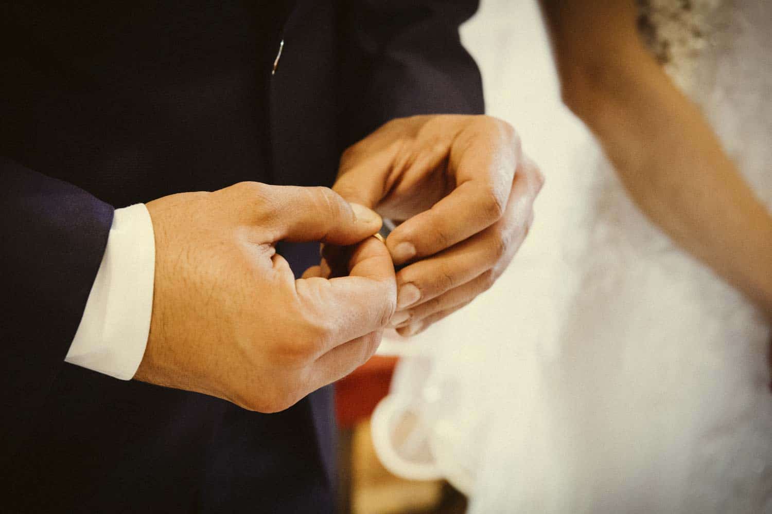 lo sposo tiene in mano la fede nuziale della sposa